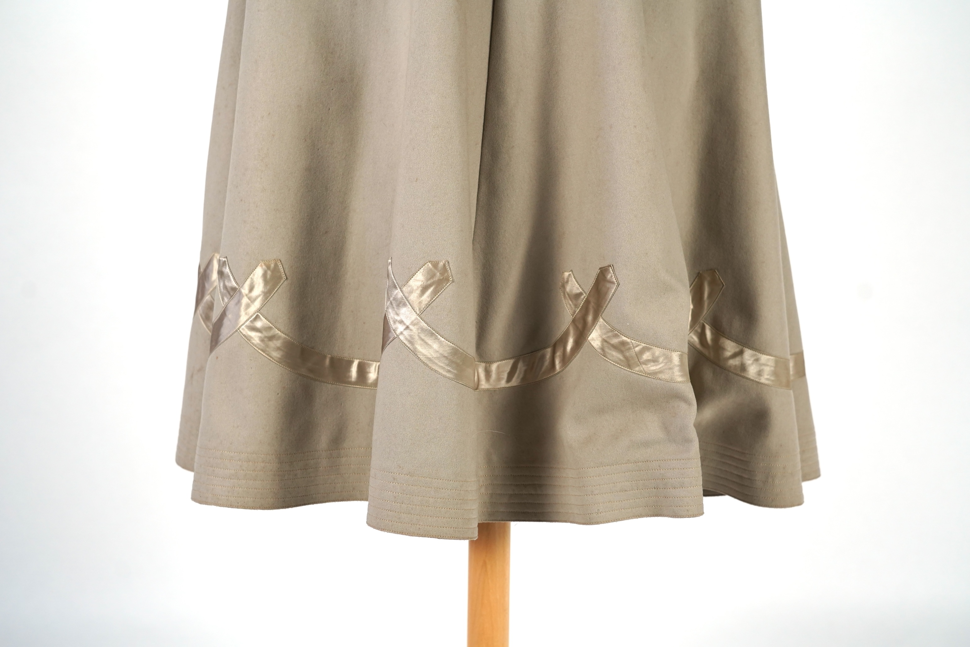 An Edwardian mushroom wool evening cape, decorated with silk ribbon worked strapping and ornate appliquéd fine braiding across the shoulders and under section of the collar, lined with cream silk satin.